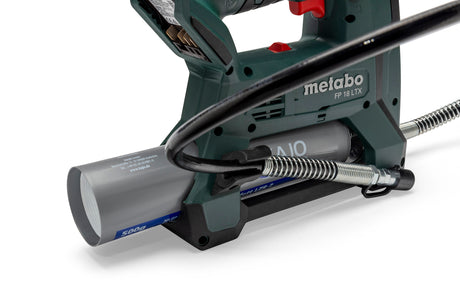 Close-up of Metabo FP 18 LTX grease gun showing grease cartridge, hose, and ergonomic handle on a white background.
